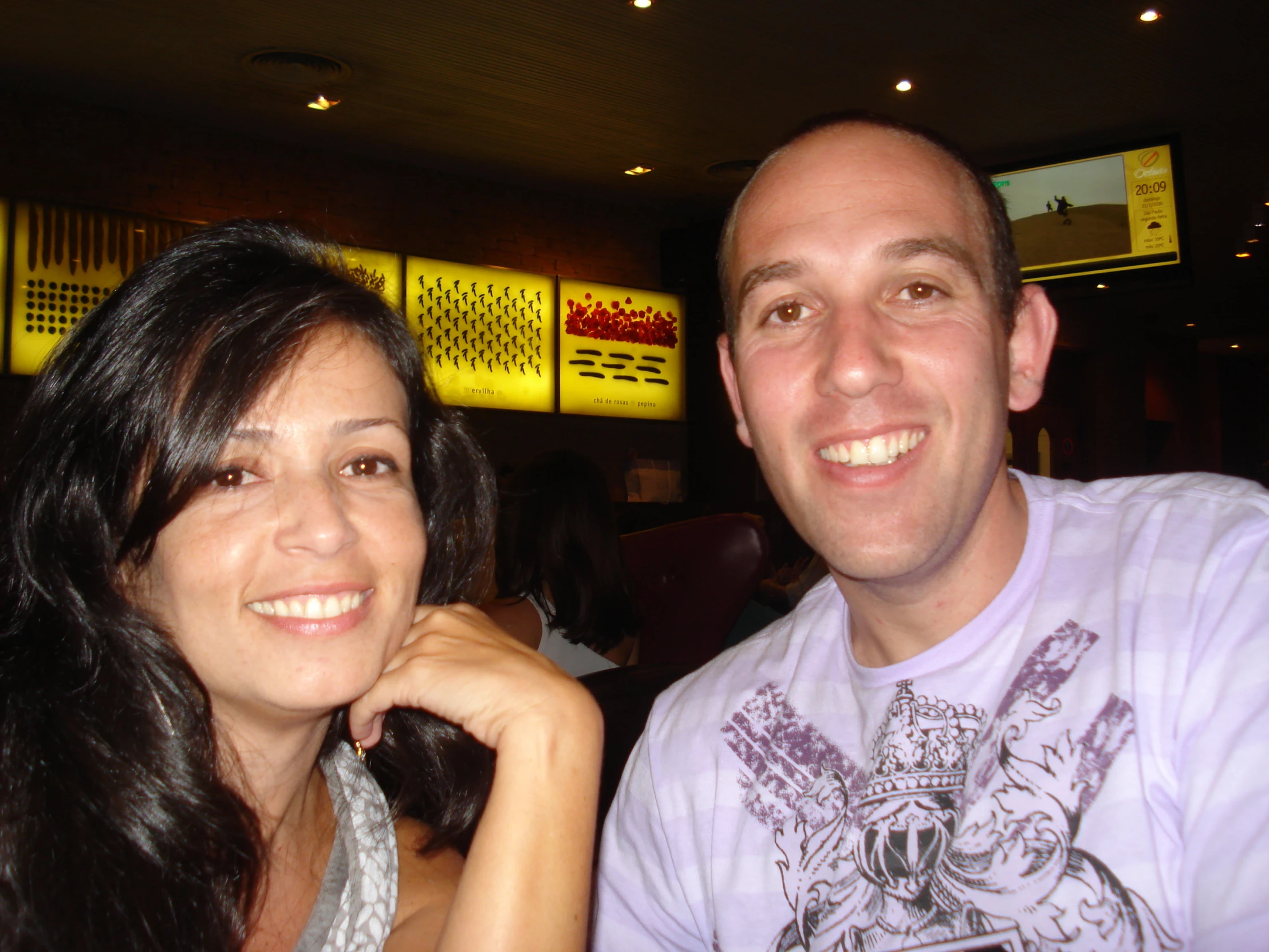 a man and woman sit together smiling for the camera