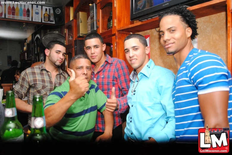 a group of young men at a pub holding beers