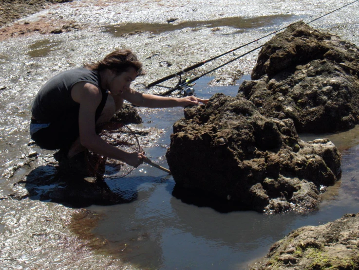 a woman with a fishing rod looks at the water