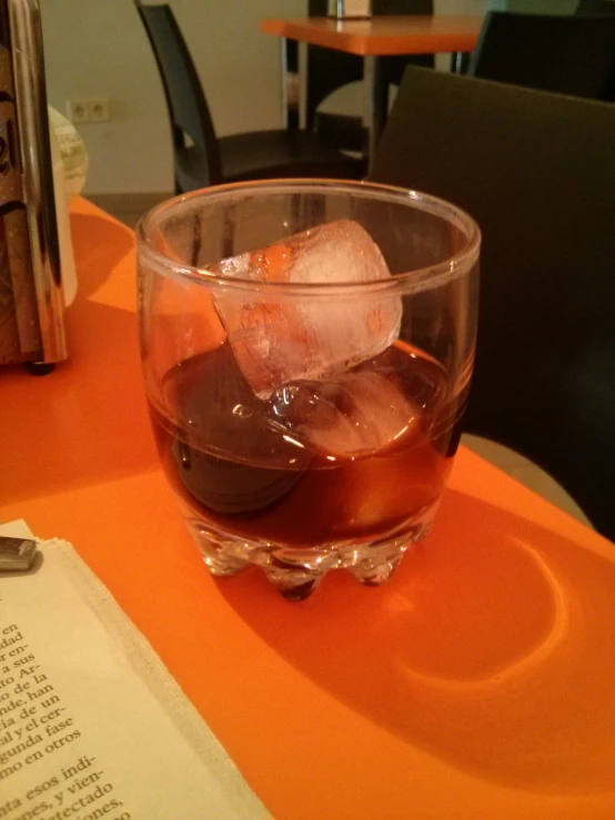 a glass filled with ice on top of a table