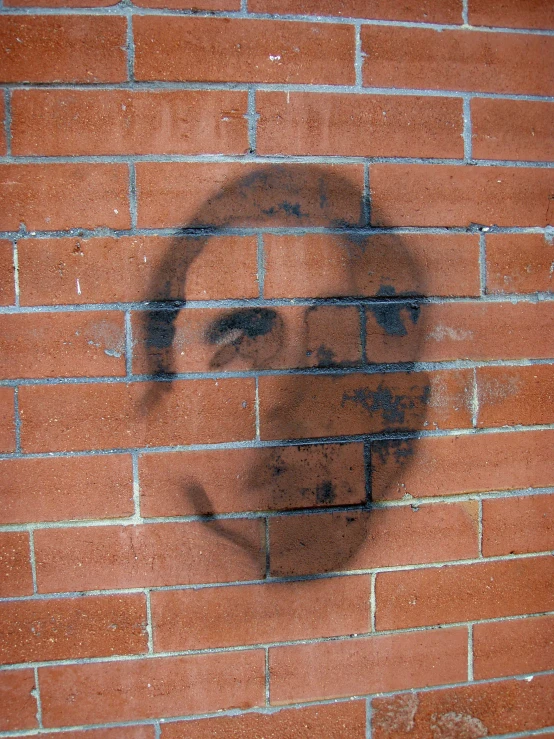 a brick wall with a black and white drawing of a woman on it