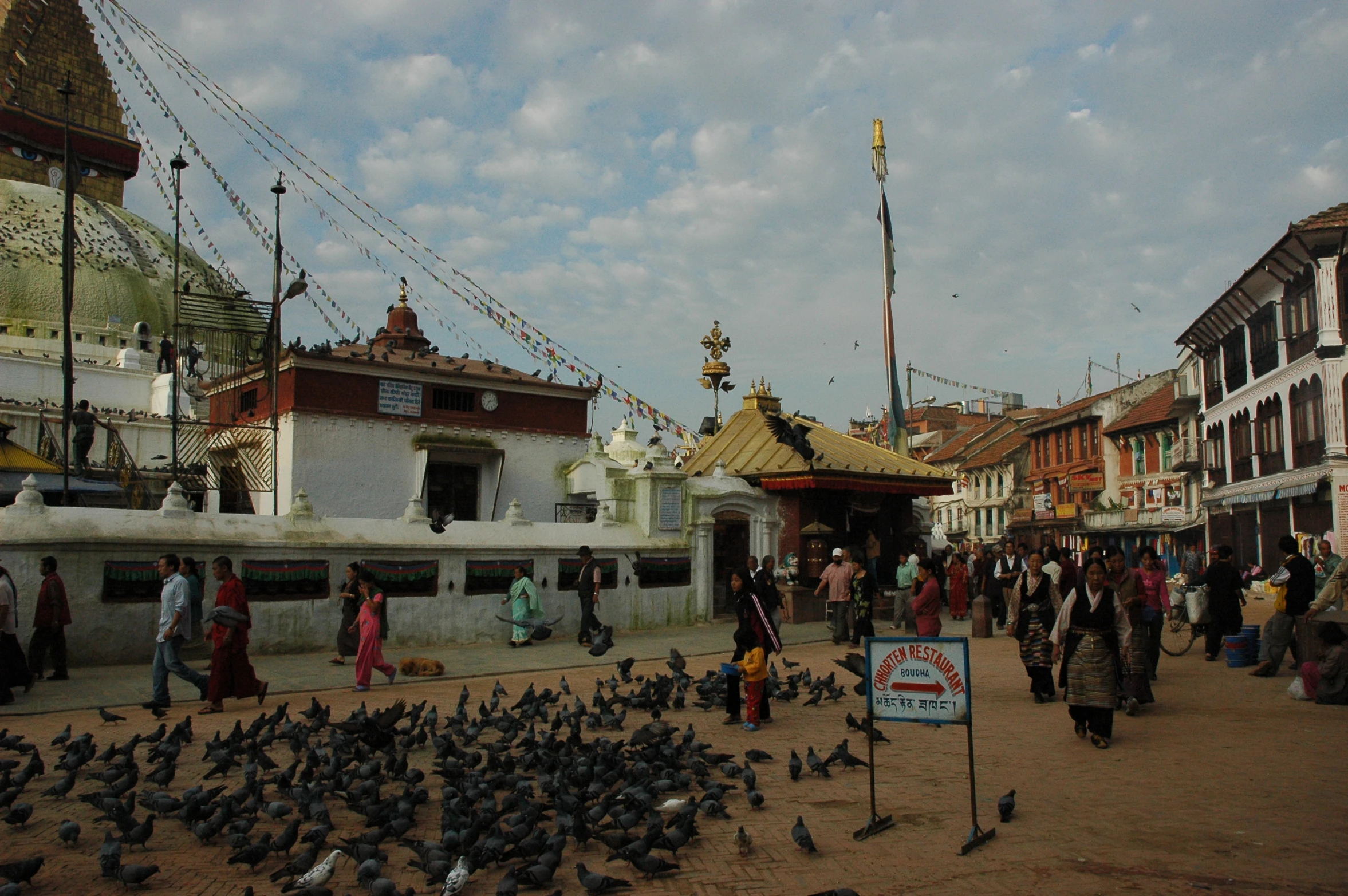 many people walk around in front of many buildings