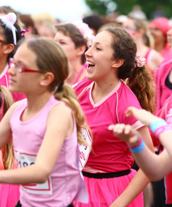 many girls in pink dresses standing in a line