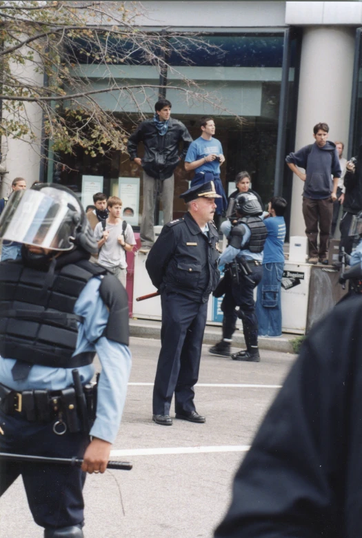 a man in blue is walking near a group of police officers