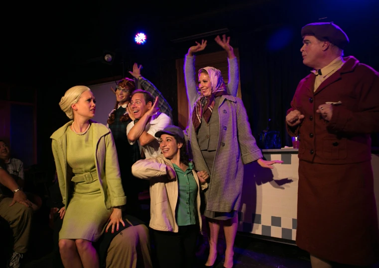 three women stand in front of men dressed in vintage clothing