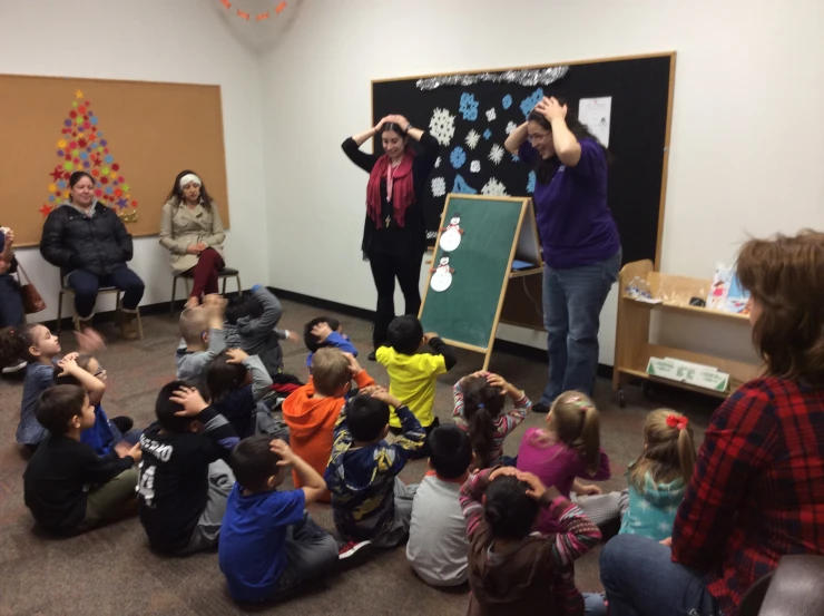 two girls give presentation to children in a classroom