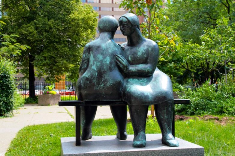 a statue sitting on a table with two people looking at soing