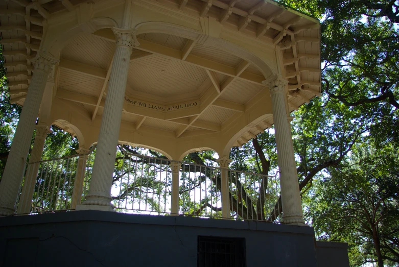 a wooden gazebo sitting between some trees