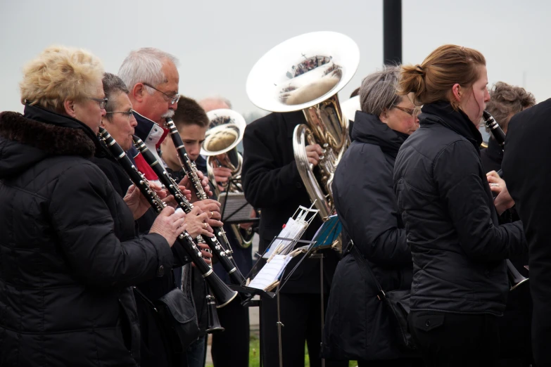 several men and women standing together with a group of instruments