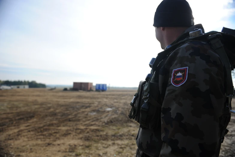 a man in camouflage with a black hat and backpack