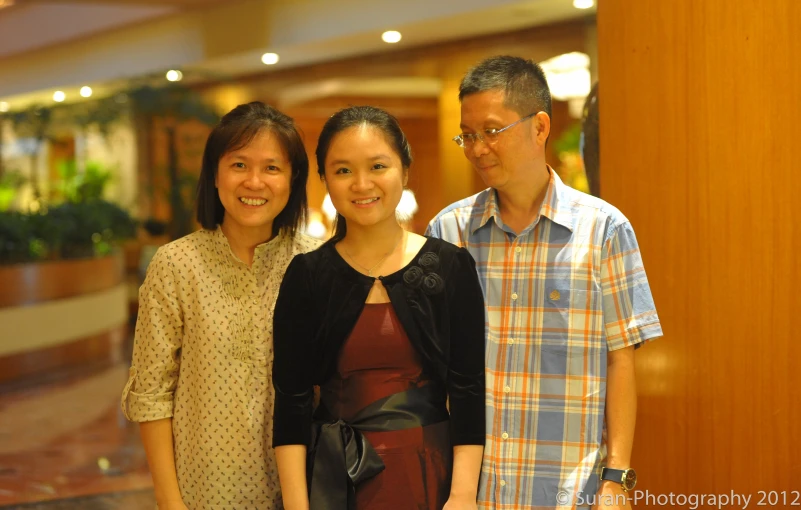 two men and one woman standing next to each other smiling for the camera