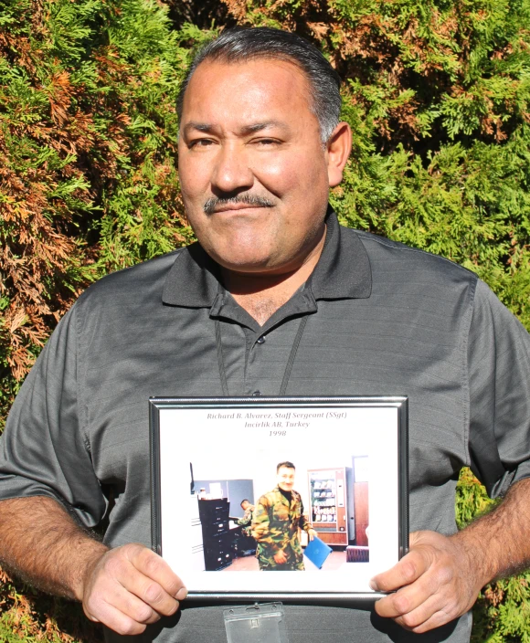 a man is holding up a picture with his mustache