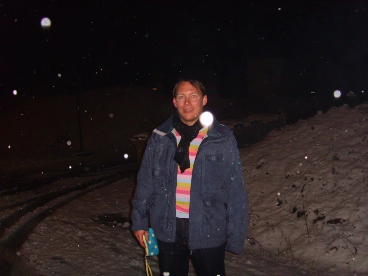 a man in his early twenties, wearing a scarf and snow shoes