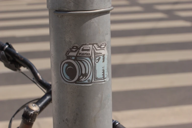 a sticker on a pole that has a camera on it