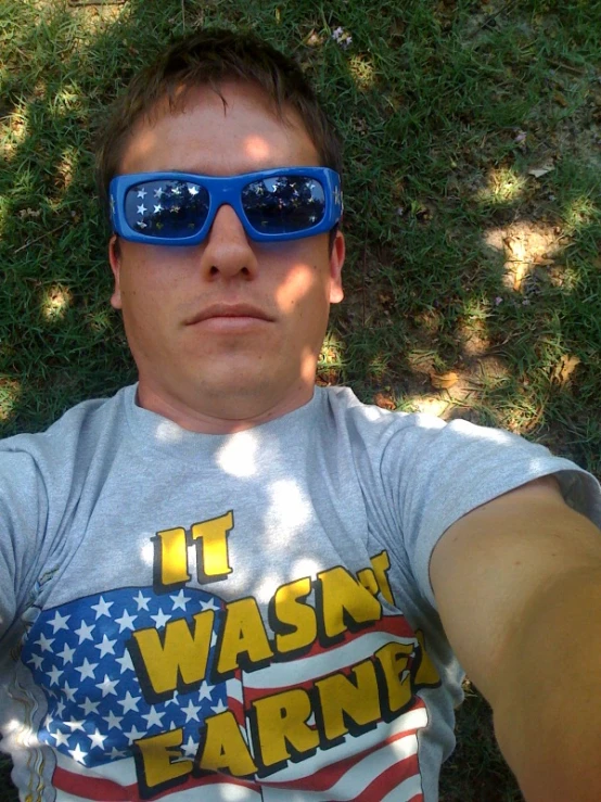 a person is sitting on the grass and wearing glasses