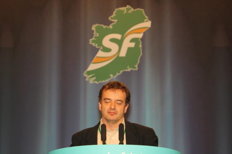 a man in a suit speaking into a microphone