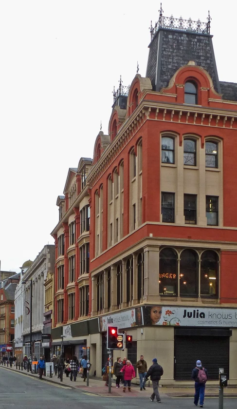 people walking in front of a very large building on a city street