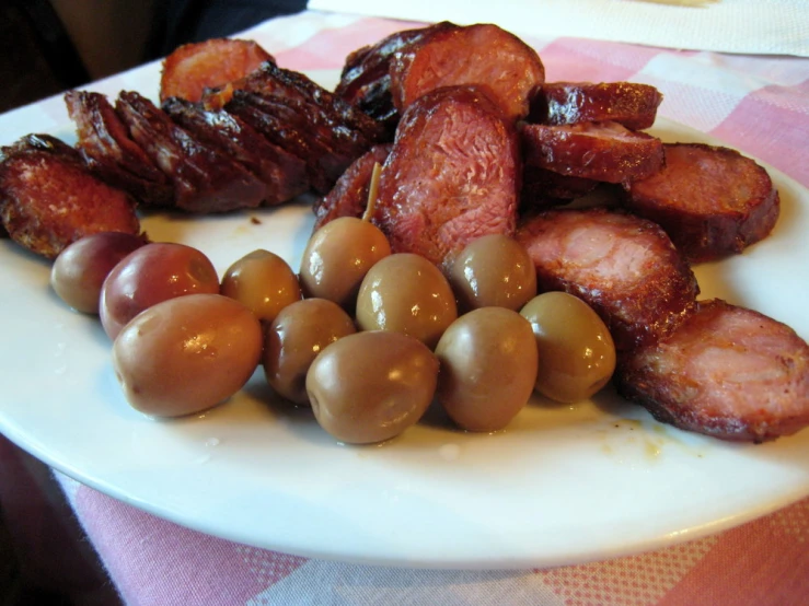 some ham and olives on a white plate