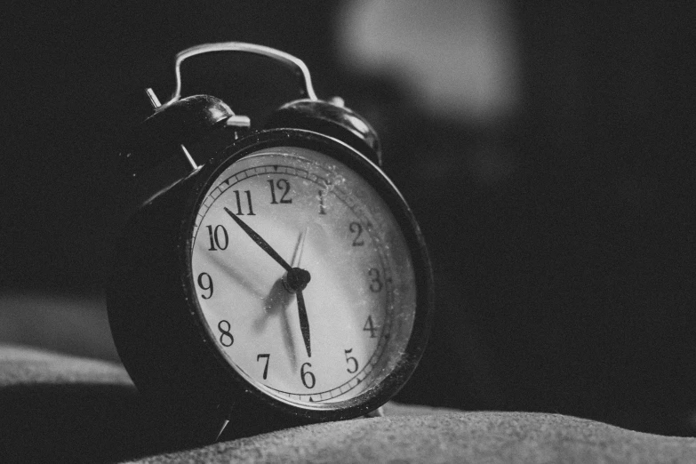 an old alarm clock sitting on a pillow