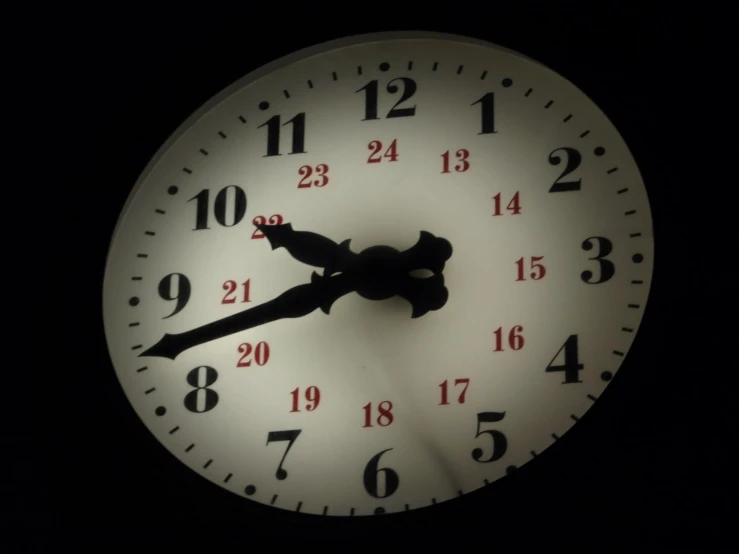 a white clock showing the times at 2 13 on black background