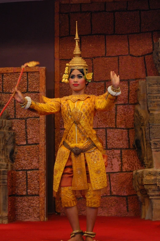 a woman dressed in traditional thai dress performing on stage