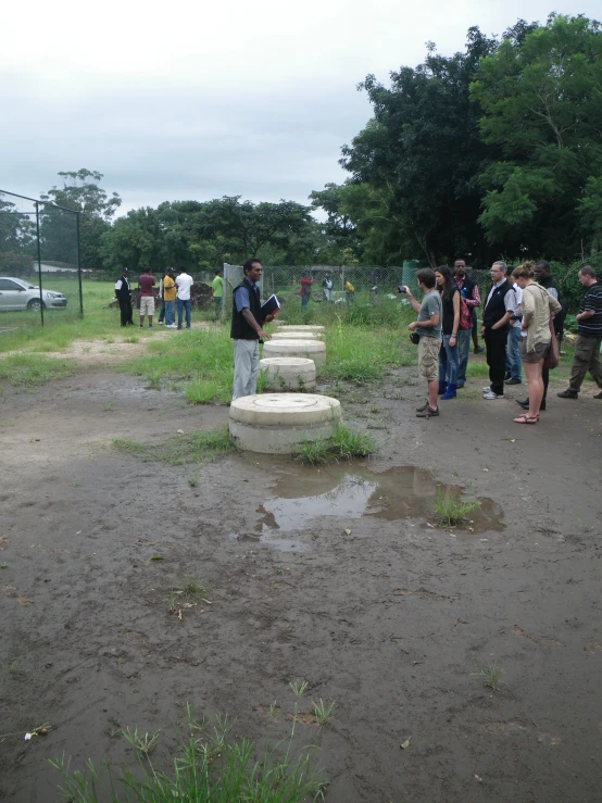 a group of people stand in a muddy area