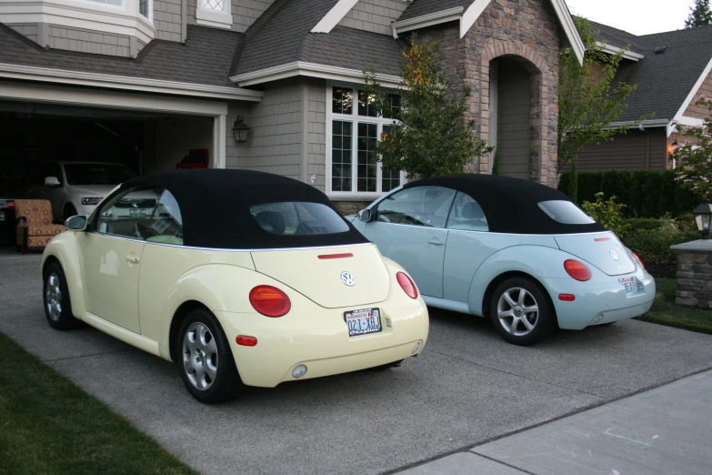 two yellow and blue car are parked in front of a house