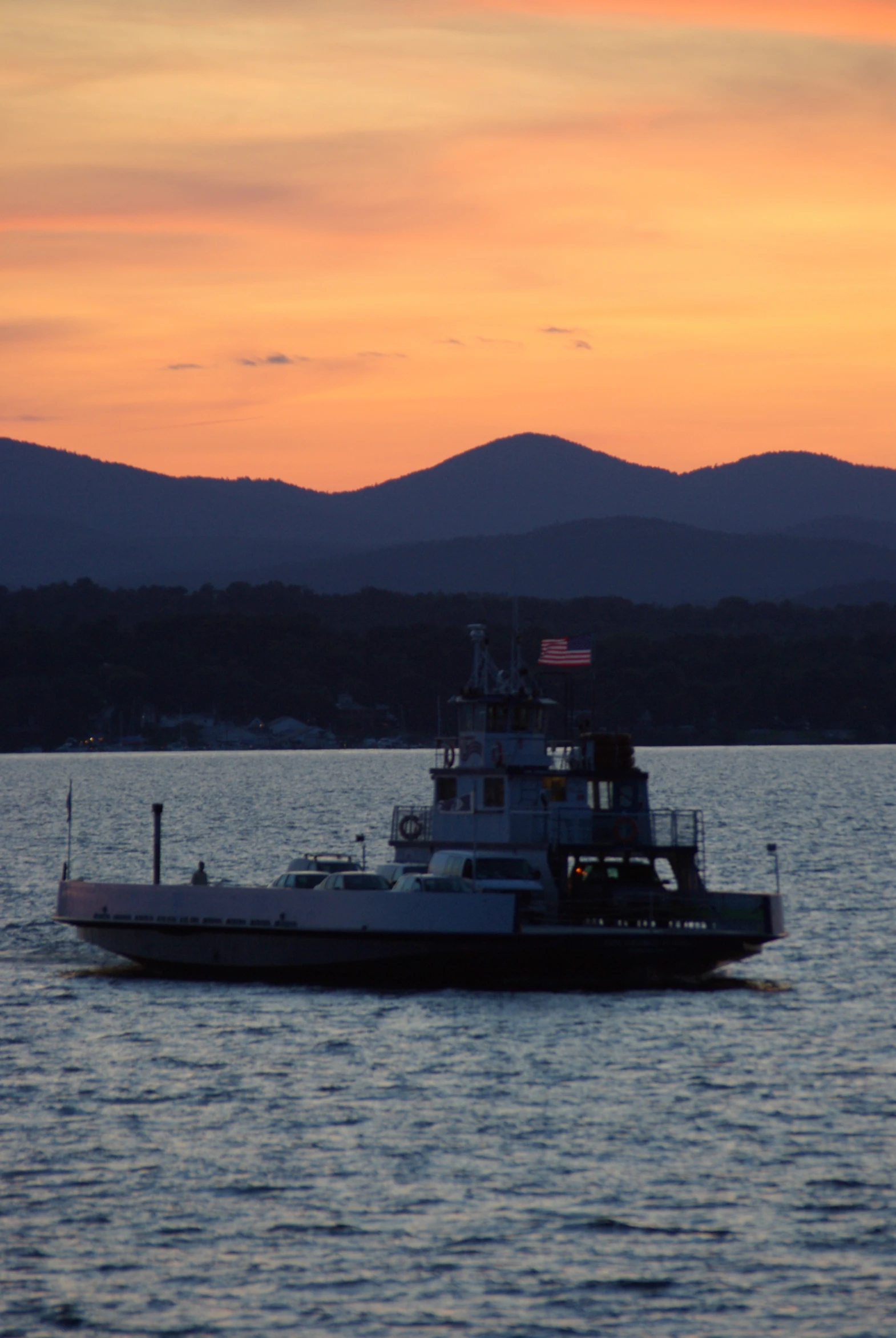 the white boat is in the water with mountains in the background