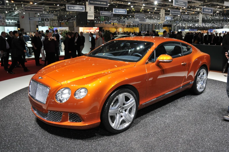 an orange bentley muls down at the auto show