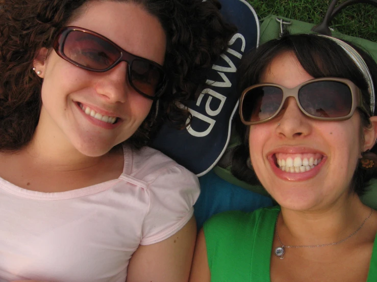 two women with sunglasses are laying next to each other