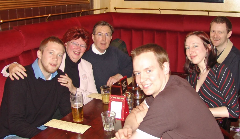 a group of people sitting around a wooden table