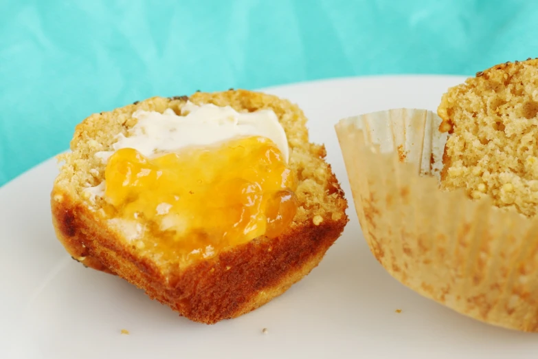 a muffin with cream cheese is sitting on a plate