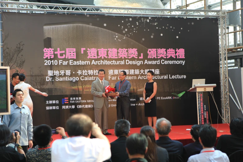 people stand at a podium in front of a stage