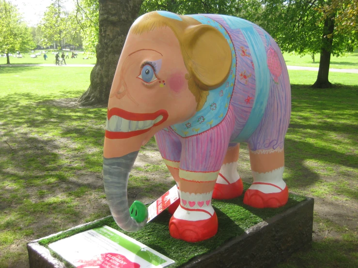 a statue of an elephant sitting on top of grass