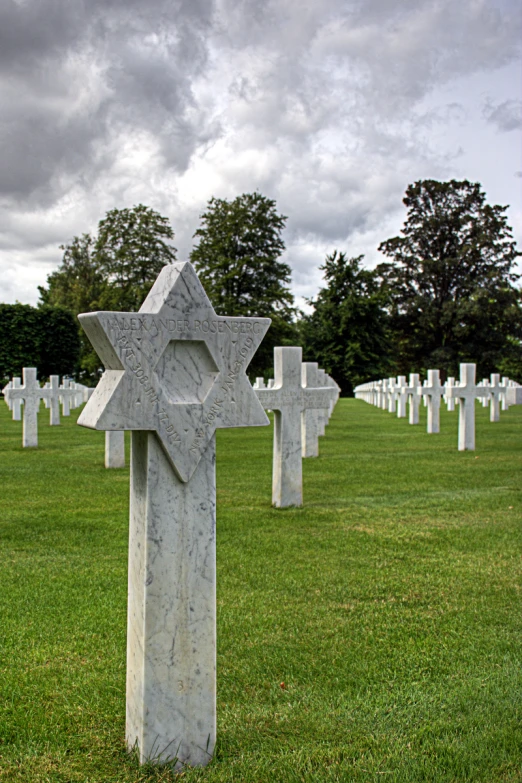 a large cross stands in the middle of the grassy area