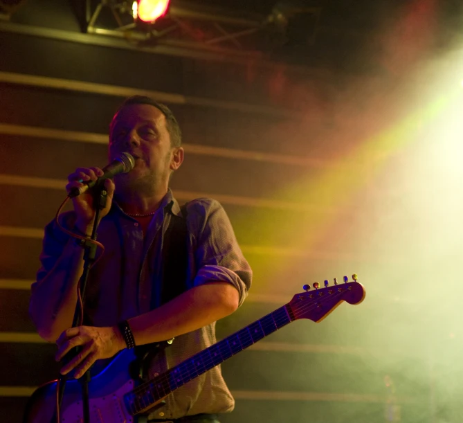 a man that is standing up with a guitar