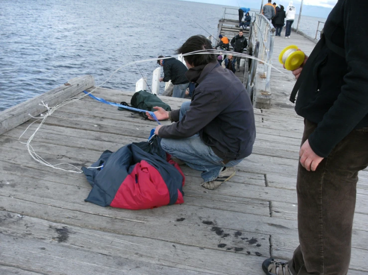 several people are fishing off the dock together