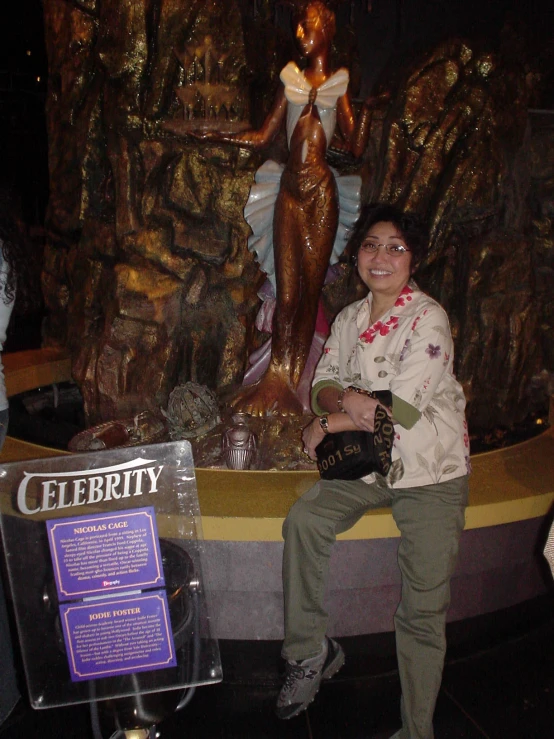 a woman sitting on a fountain in the middle of a museum