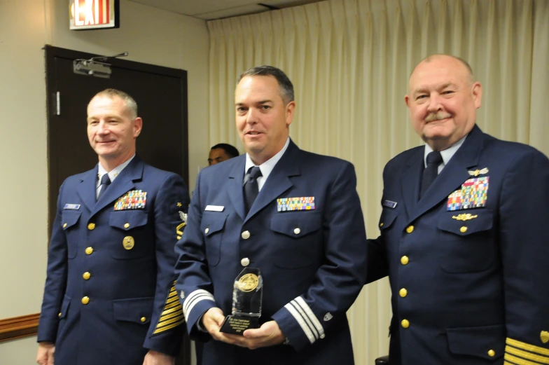 three men in navy uniforms standing next to each other