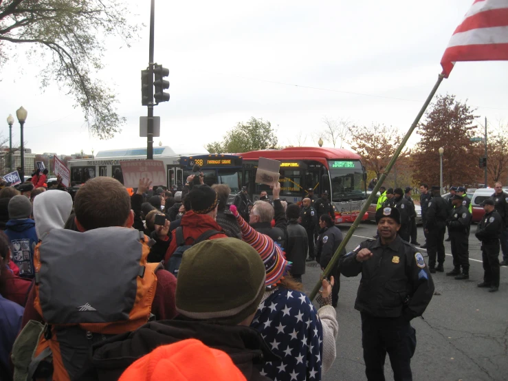 a crowd is standing outside watching a man deliver soing to the bus