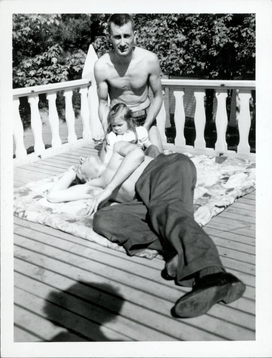 two people are laying on a blanket on a porch