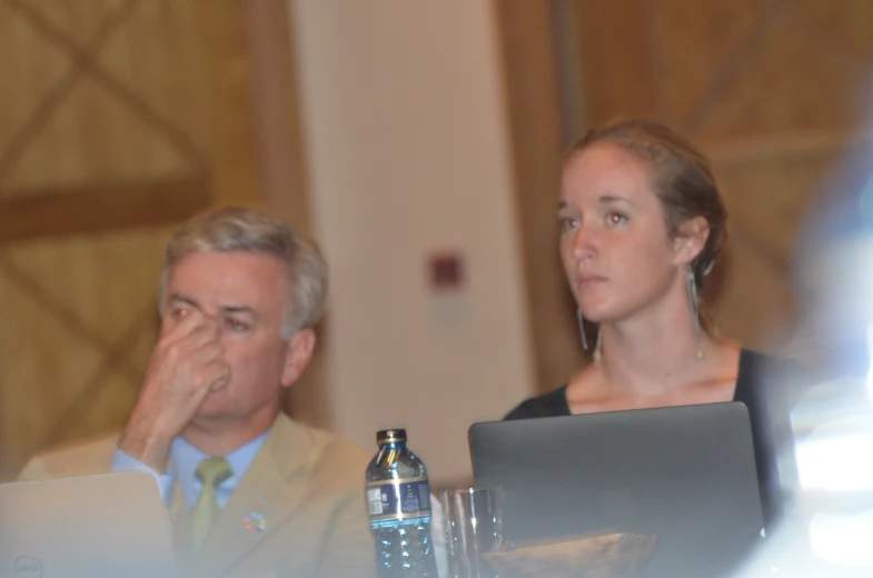 a woman with a laptop sitting next to a man