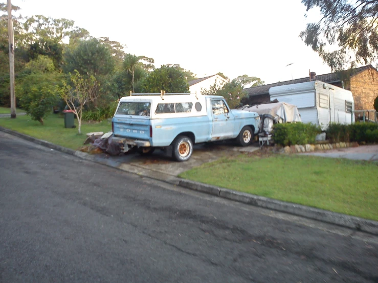 an old van in the street with a trailer and trailer