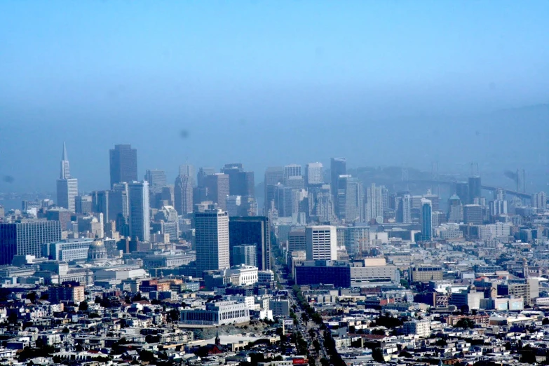 the view from a hill shows tall buildings and a lot of greenery