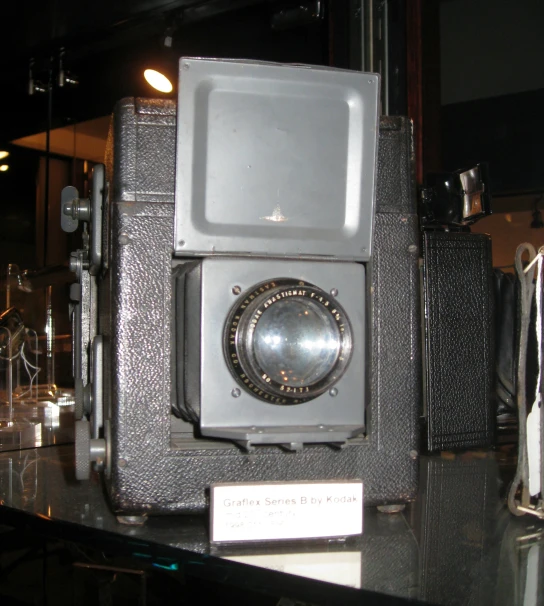 an old camera sits on top of a black table