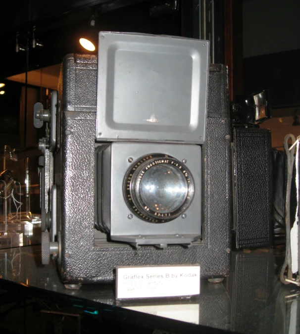 an old camera sits on top of a black table