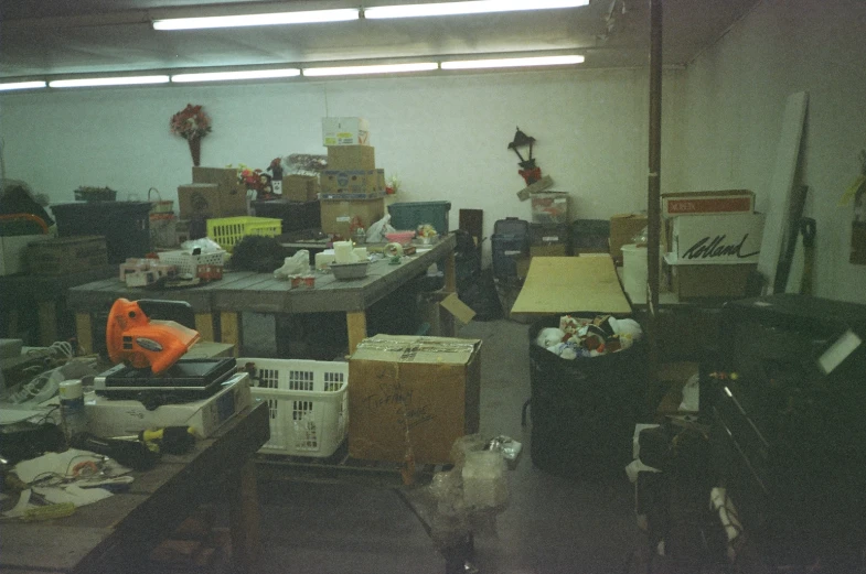 a room full of clutter and boxes and a small lamp