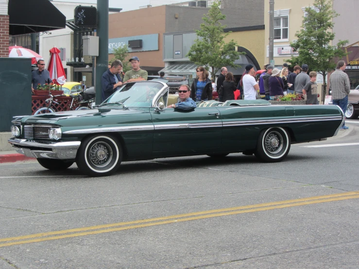 a car parked next to a crowd of people on the sidewalk