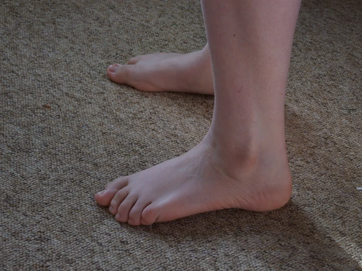 a person's bare feet are sitting on the floor
