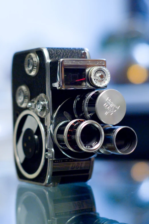 a very old fashioned camera on display on a glass table